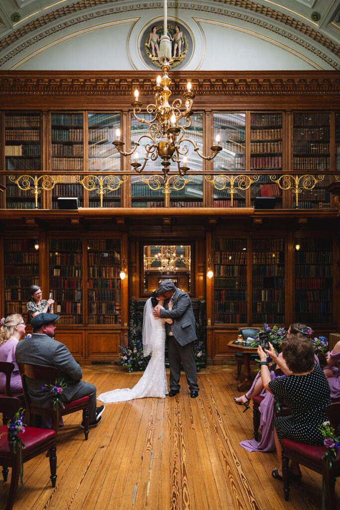 Couple exchanging vows inside grand wood-paneled library.