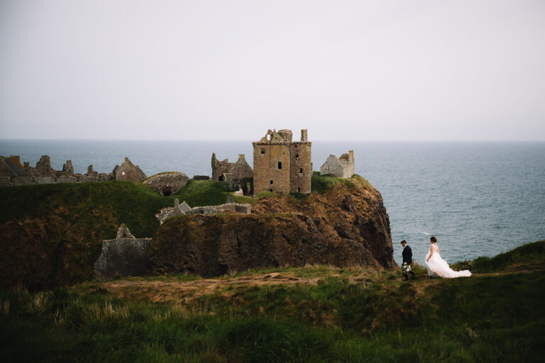 Coastal view with castle ruins on cliff overlooking sea.