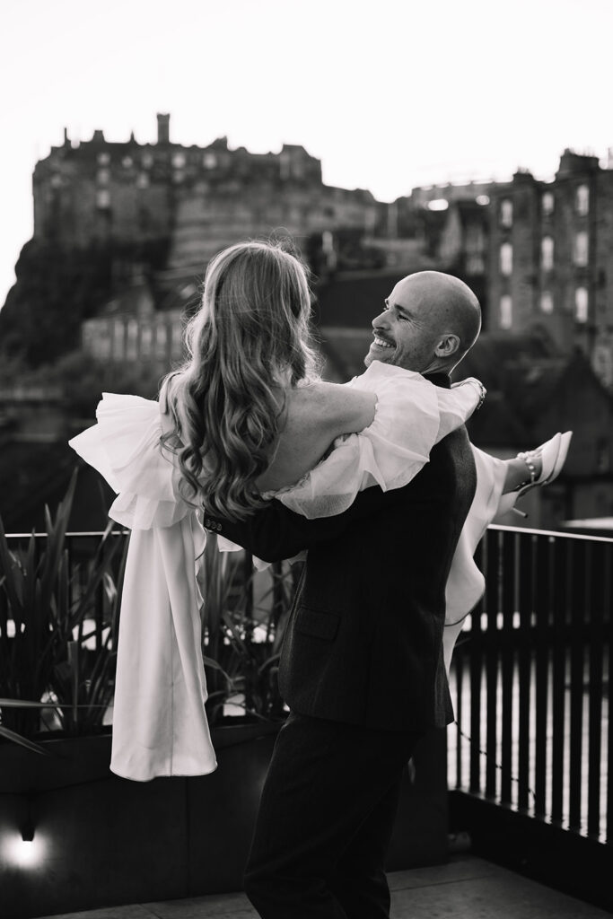 Black and white portrait of couple embracing outdoors at night.