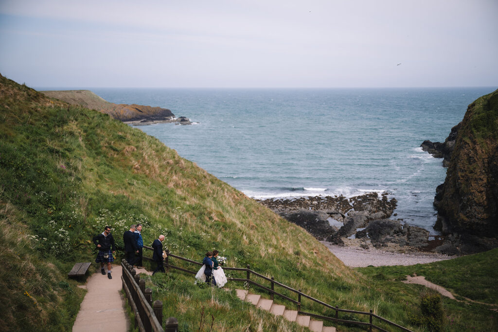 bridal party descends steps at Dunnottar Castle