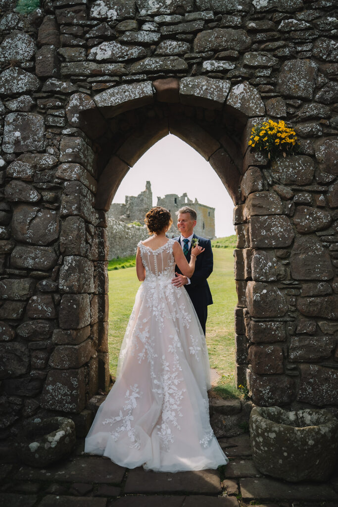 bride and groom stand in doorway at Dunnottar Castle