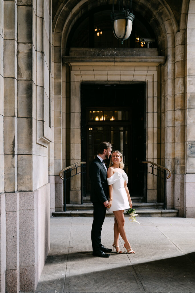 Couple standing together at entrance of stone building doorway.
