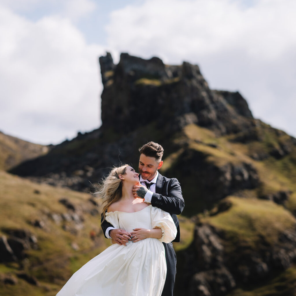 Couple embracing with rocky mountain backdrop in Scotland.