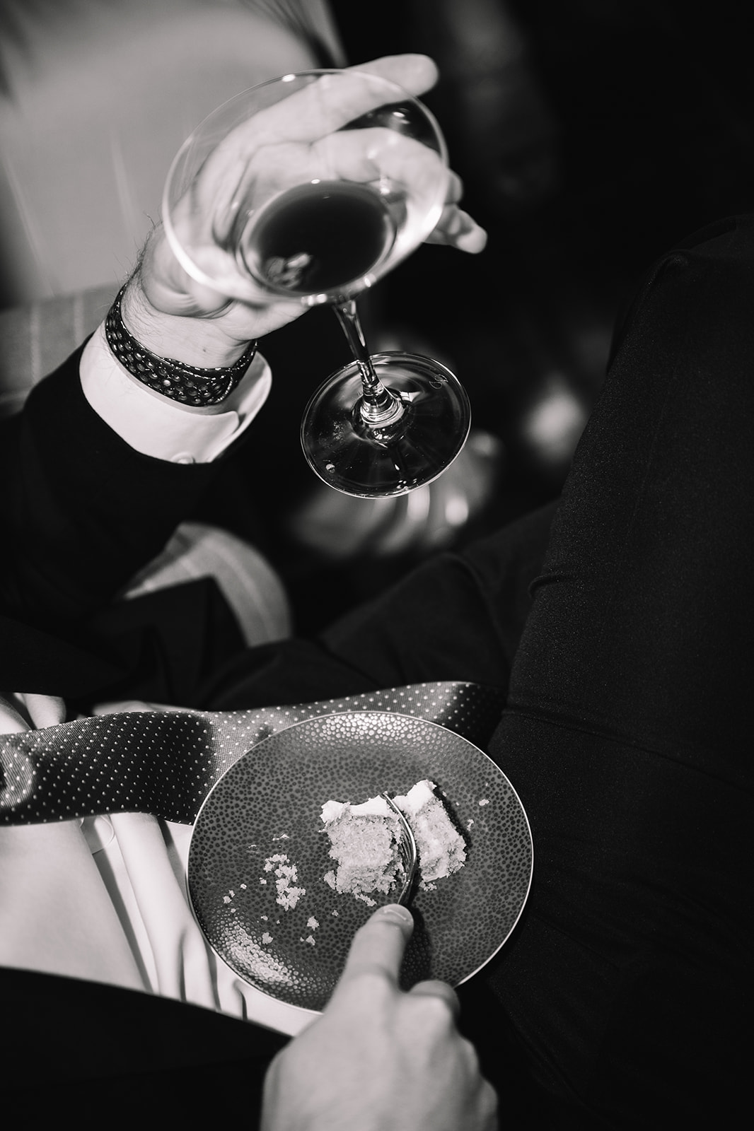Black and white close-up of hands holding wine glasses.