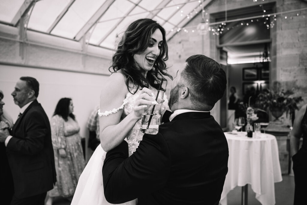 Couple dancing indoors during reception moment.