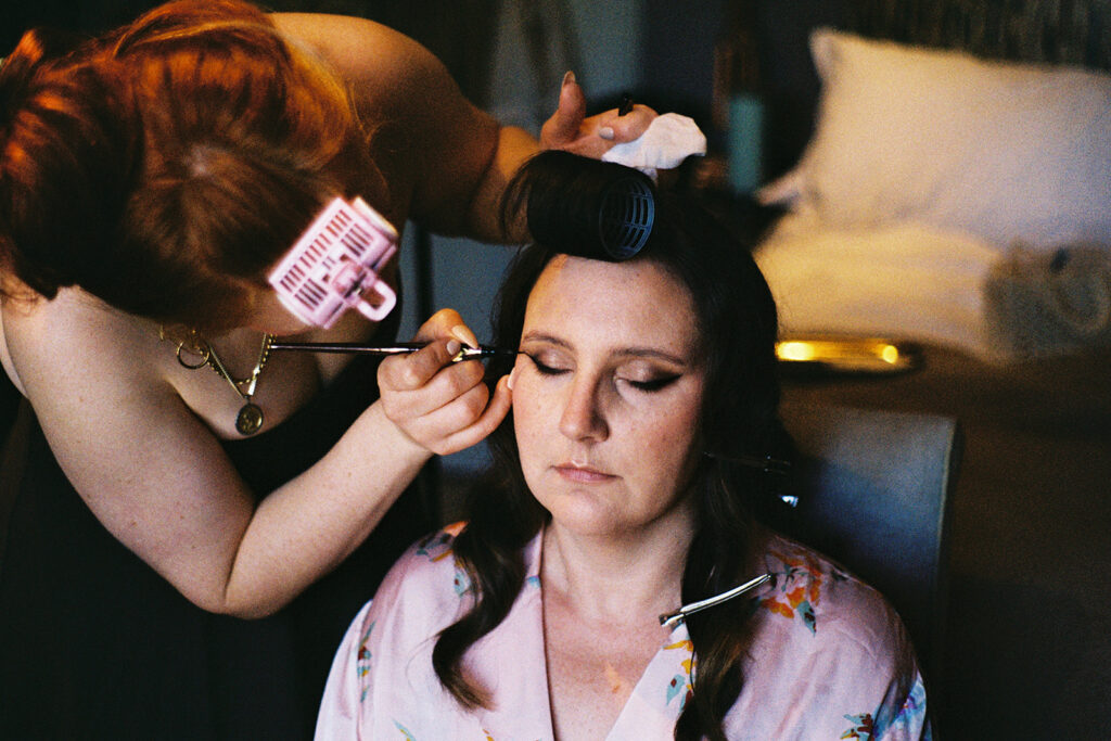 Bride getting makeup done in close-up portrait.