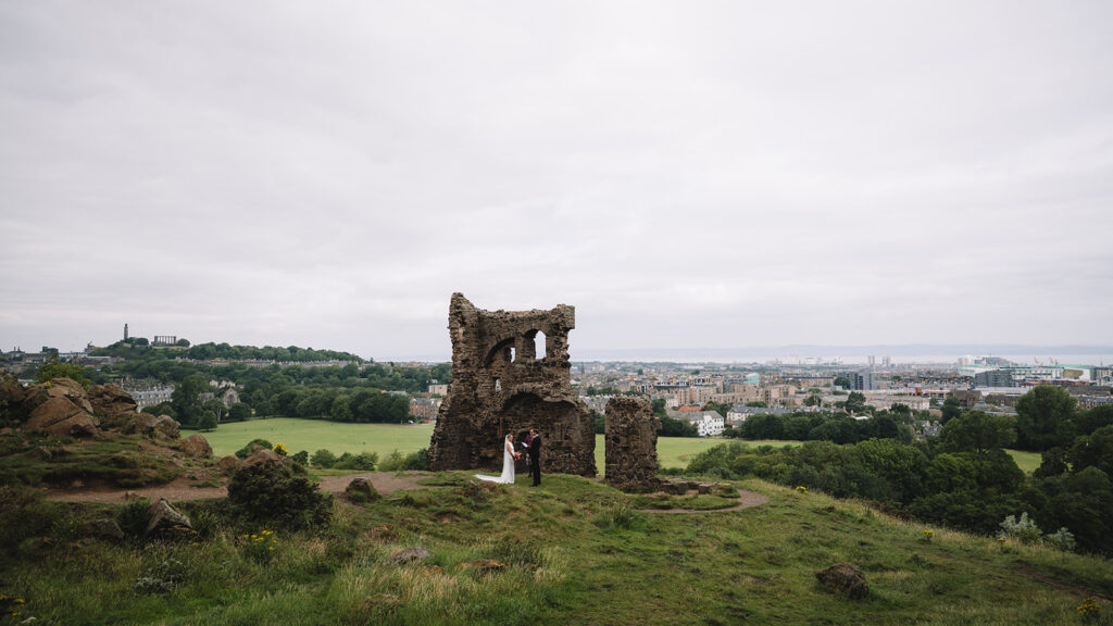 Stone ruins overlooking countryside landscape.