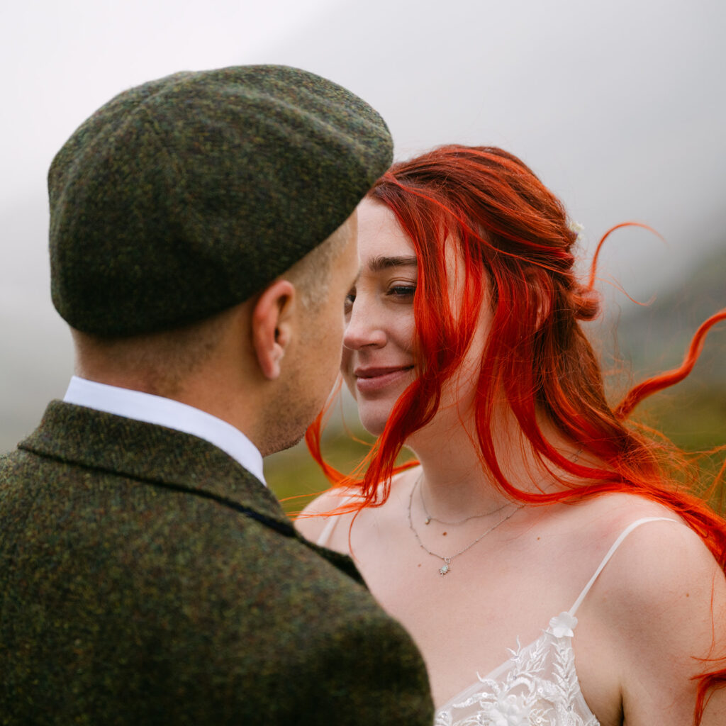 Couple sharing intimate gaze in close-up portrait outdoors.