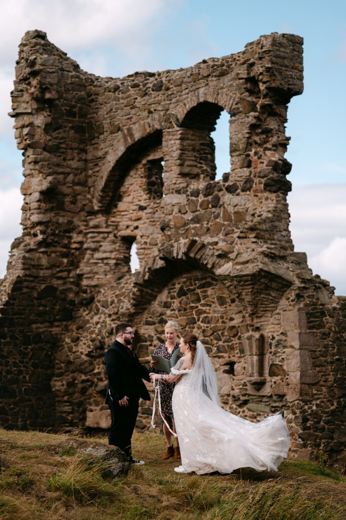 Couple standing together among stone ruins during portraits.