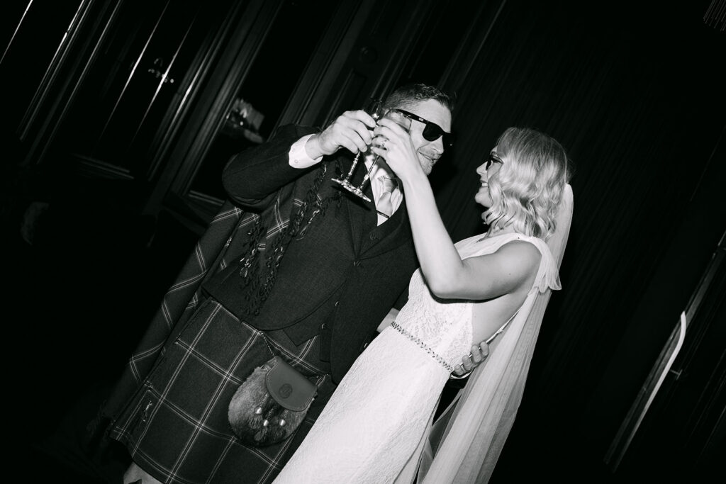 Couple dancing together in black and white reception moment.