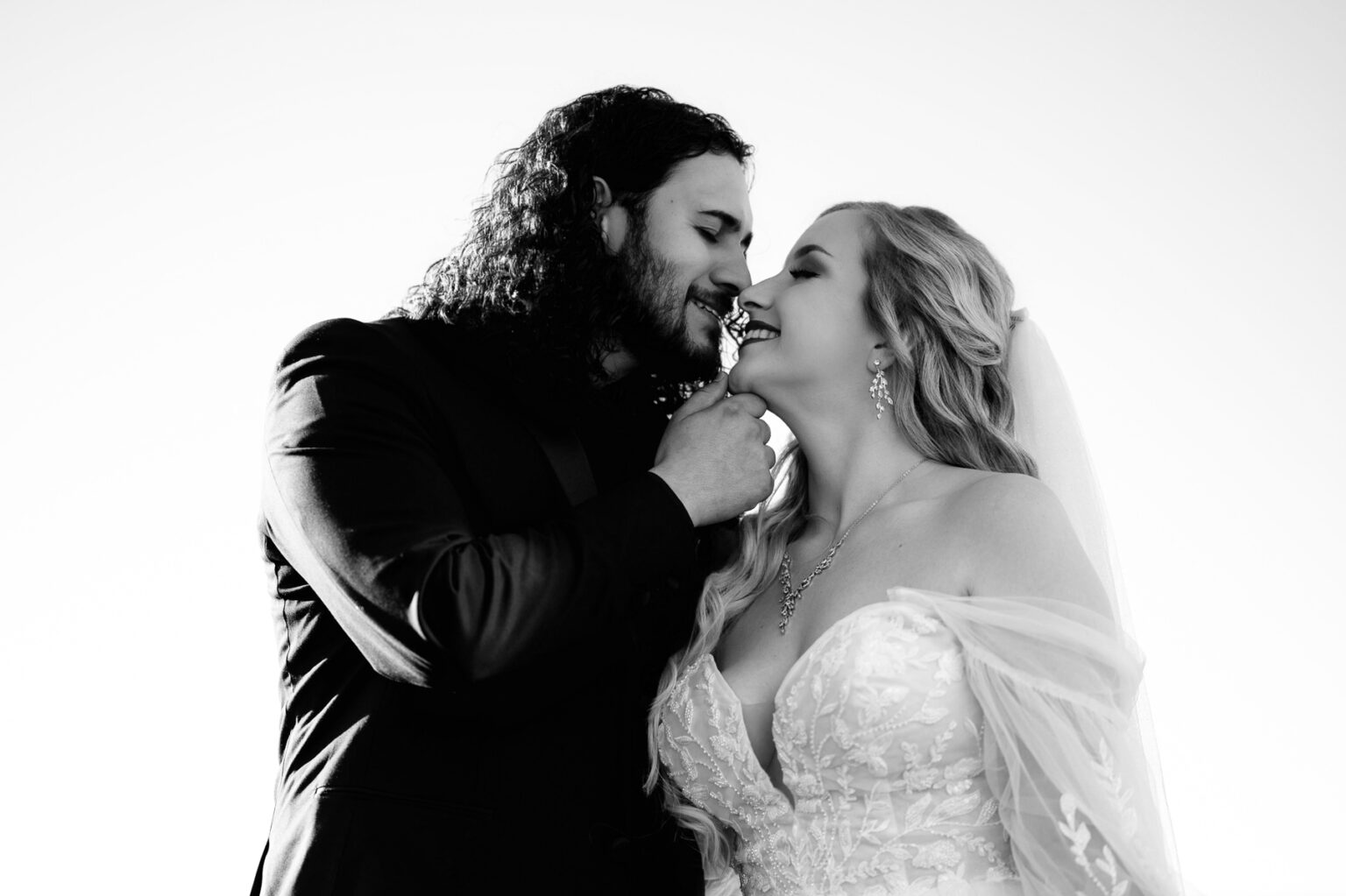 Couple sharing intimate kiss in black and white portrait.