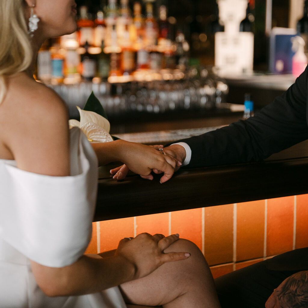 close up shot of bride and groom holding hands in glasgow bar