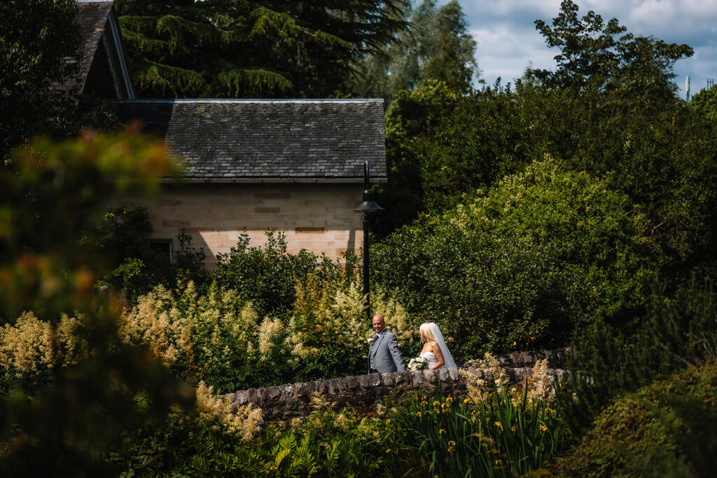 Couple seated together near small cottage in garden landscape.