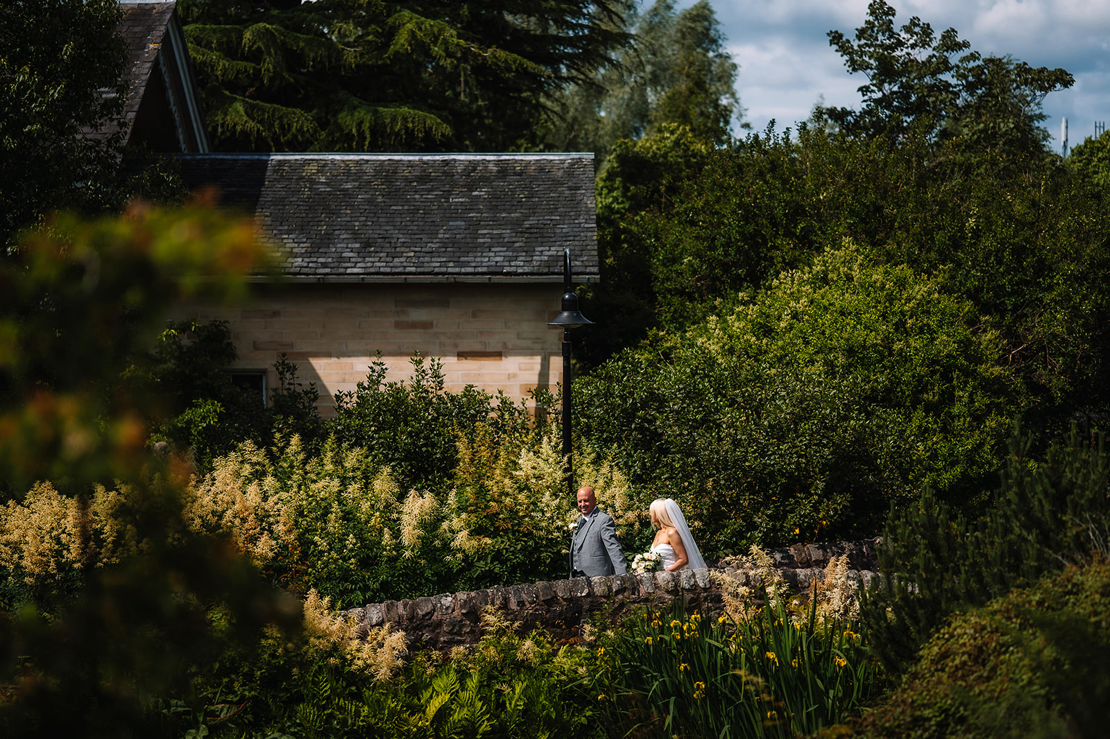 Couple seated together near small cottage in garden landscape.