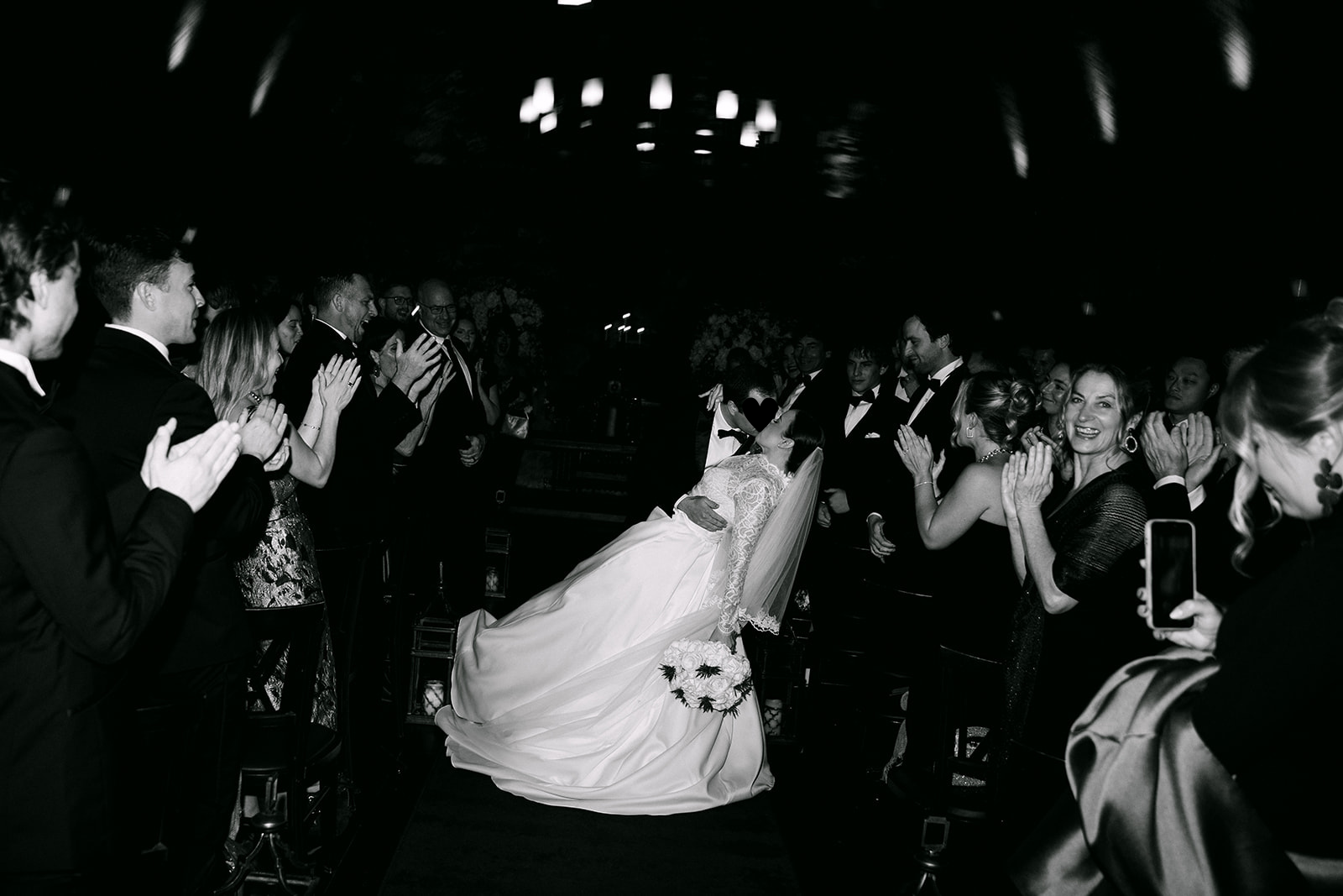 Guests dancing with bride during lively wedding reception.