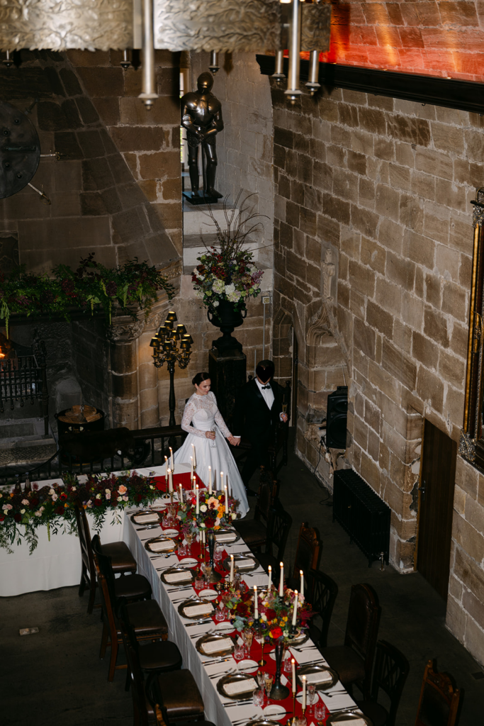 Couple standing together in rustic indoor wedding venue.