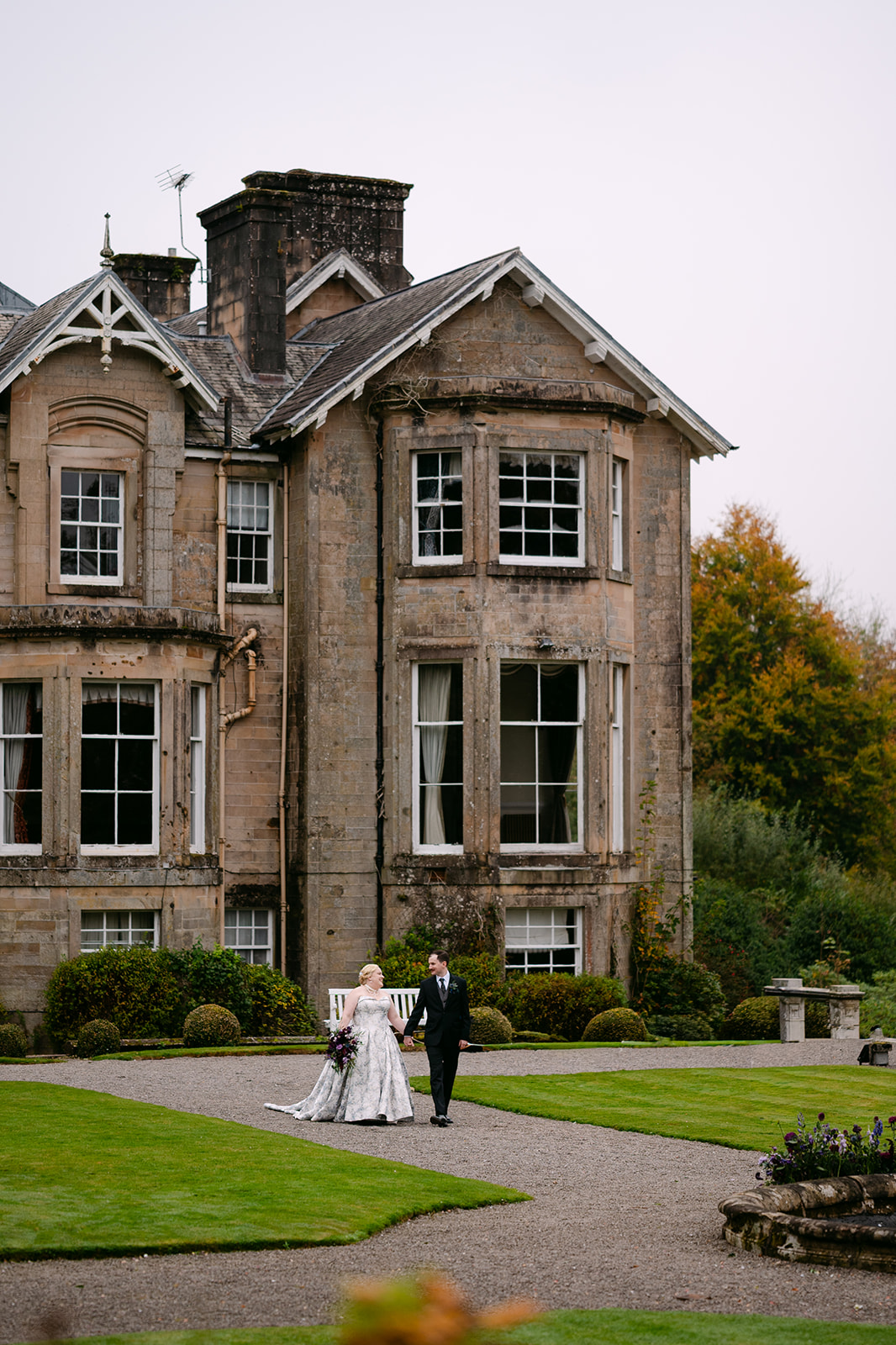 bride and groom walk away from auchen castle