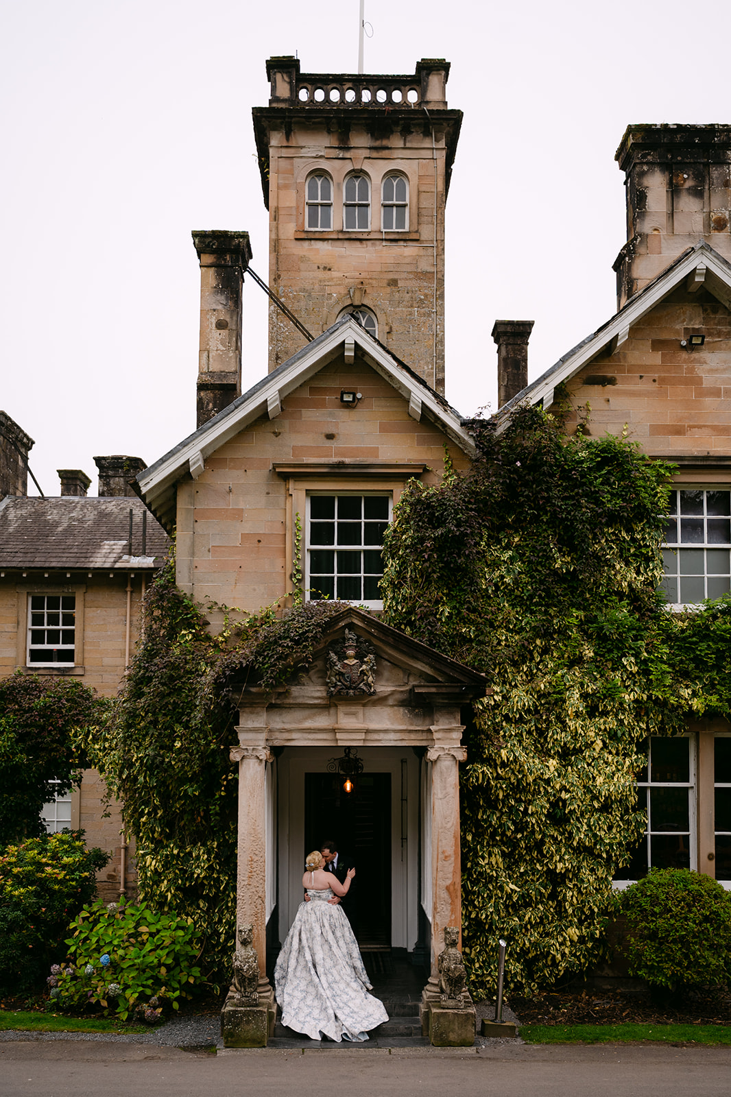 bride and groom stand in front of auchen castle