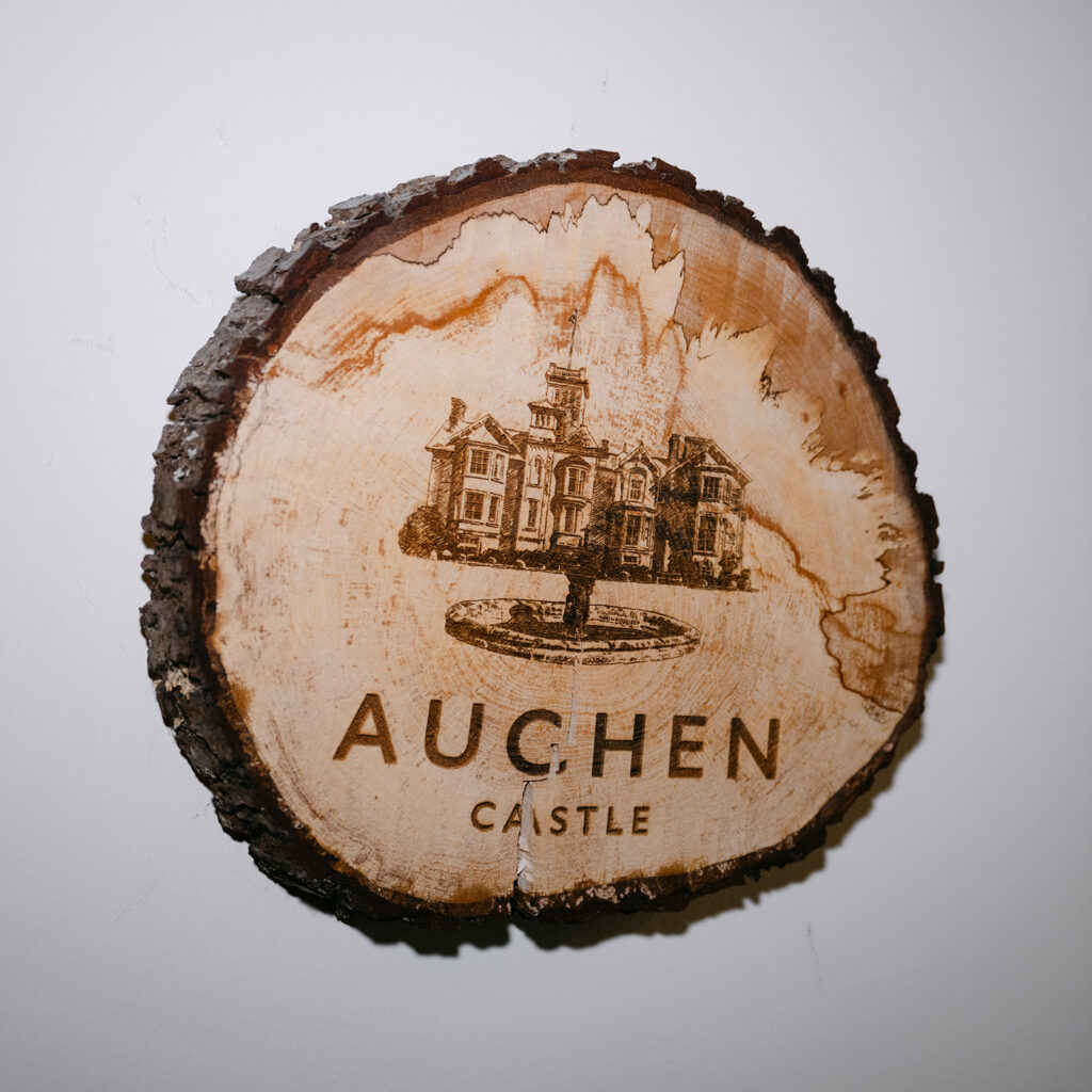 slice of wood with auchen castle stamped on it