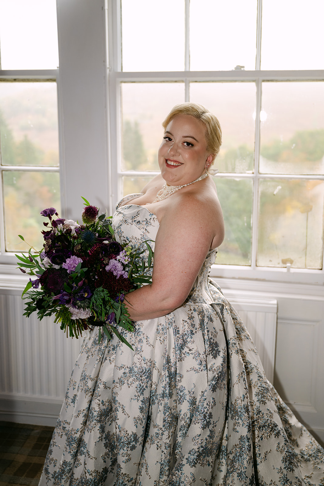 bride stands in front of window pre-ceremony at auchen castle
