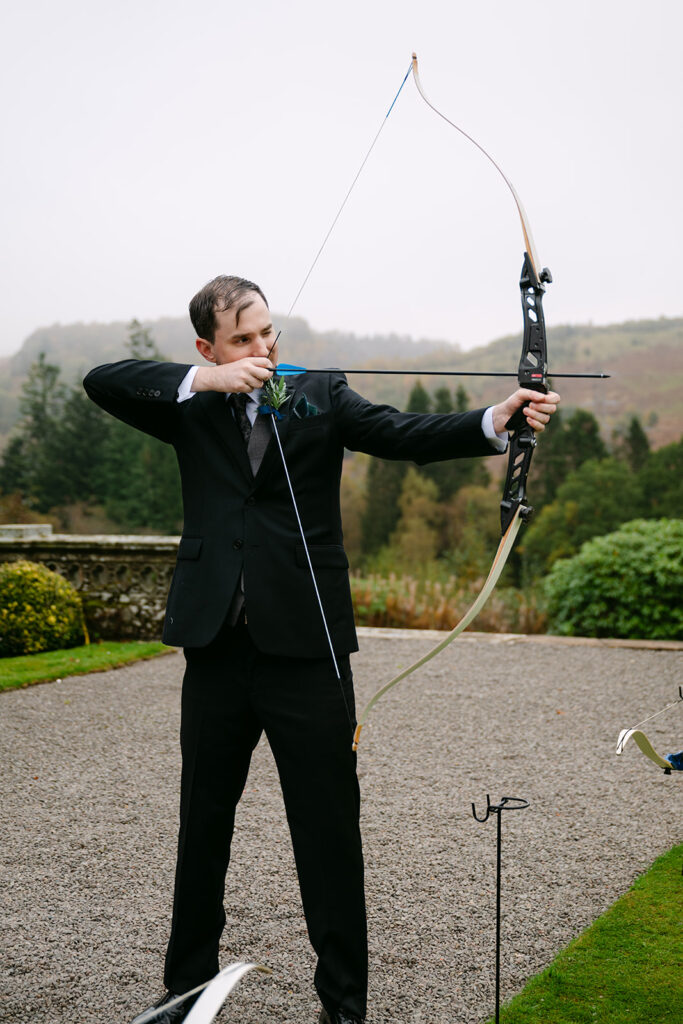 groom shoots bow and arrow at auchen castle grounds