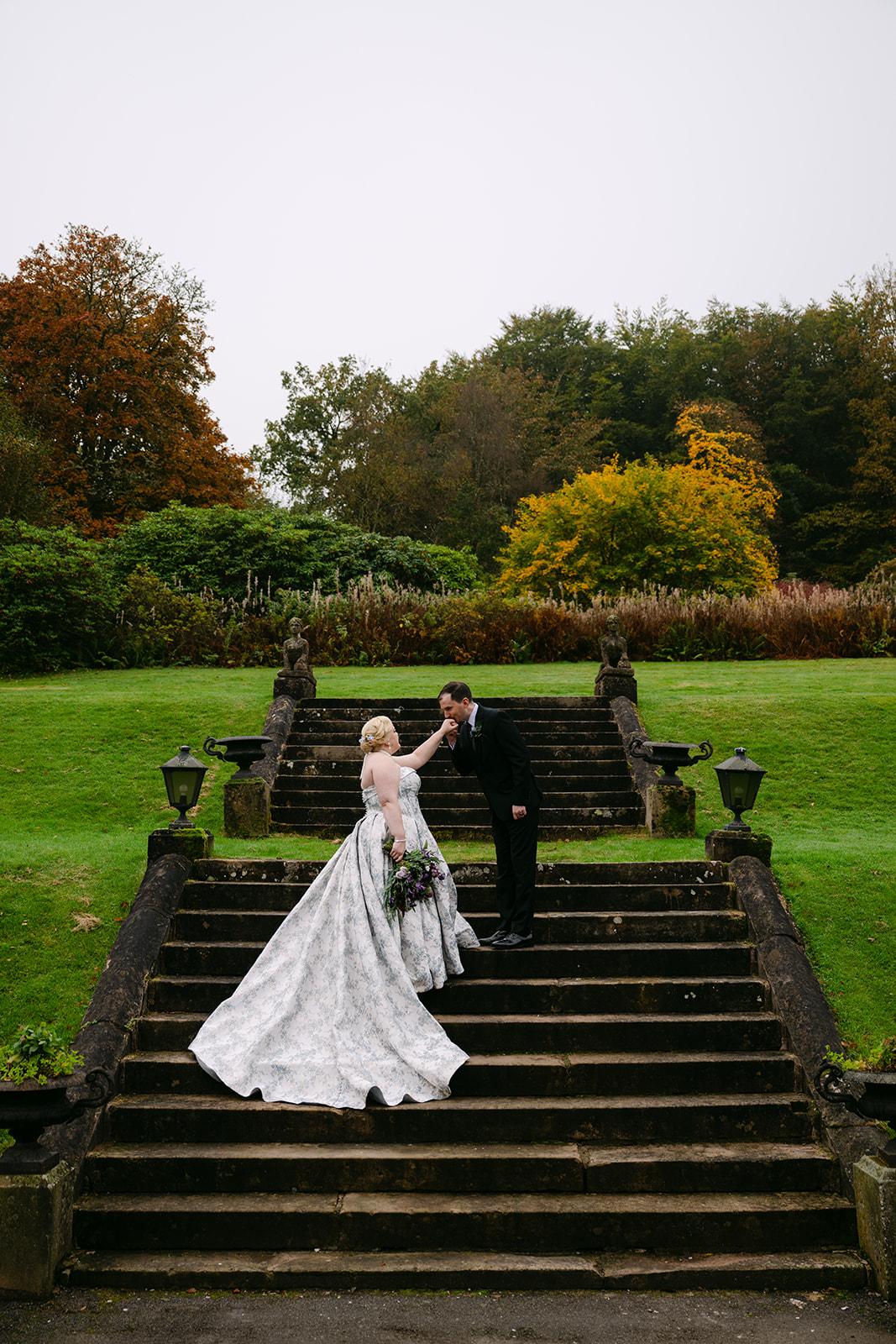 groom kisses brides hand on stairs at auchen castle