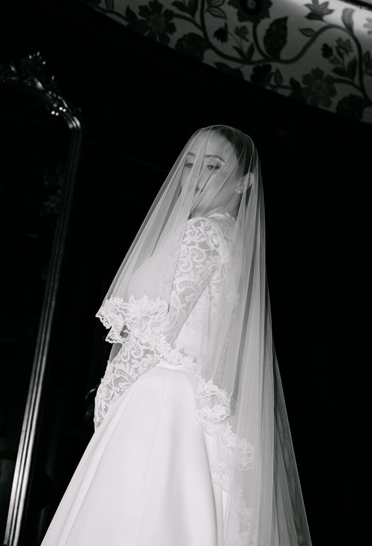 bride poses in blusher veil with heavy flash editorial photography style