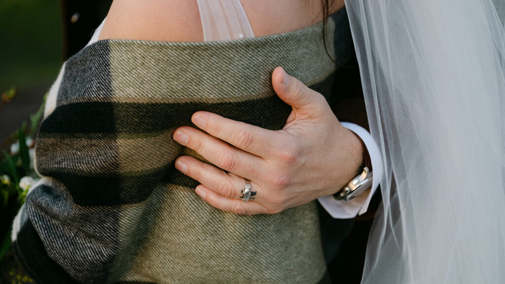 close up of rings on bride and grooms hands