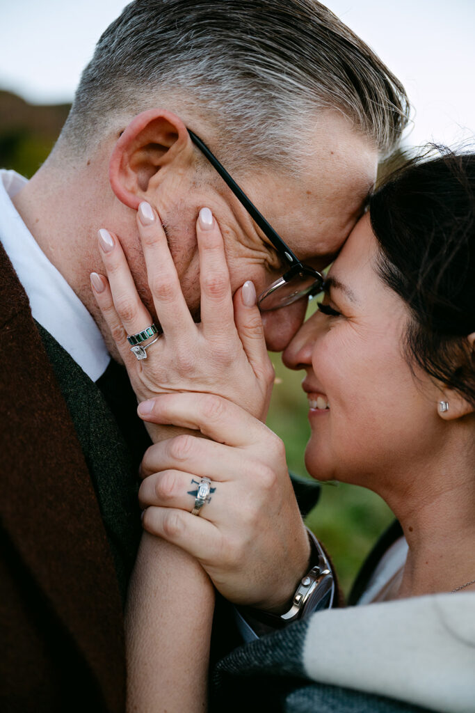 close up of rings on bride and grooms hands