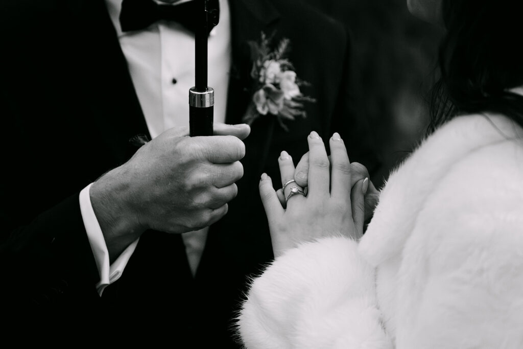 close up of rings on bride and grooms hands