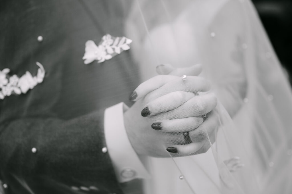 close up of rings on bride and grooms hands