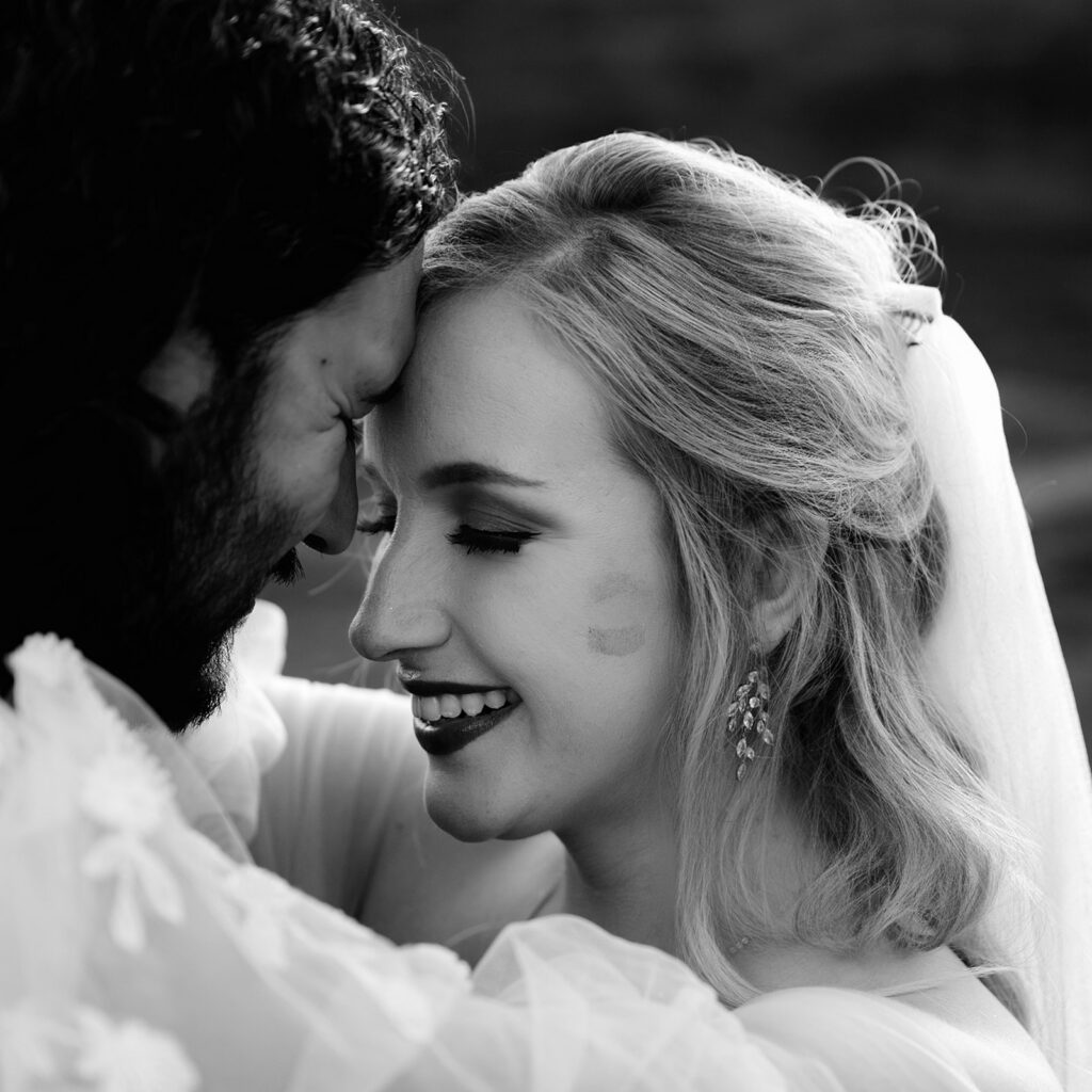 bride smiles as groom looks at her