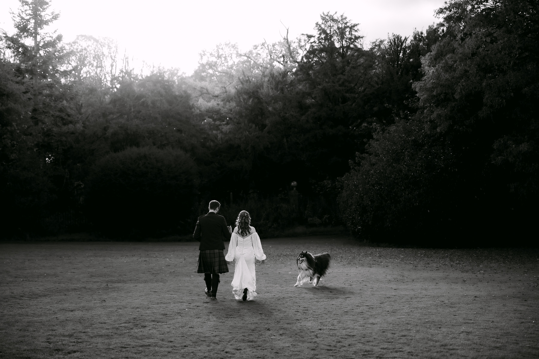 bride and groom walk with their dog at kirknewton house stables