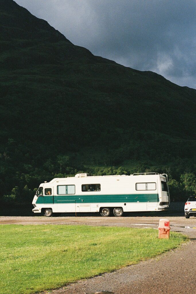 caravan parked in green field in glencoe shot in 35mm film