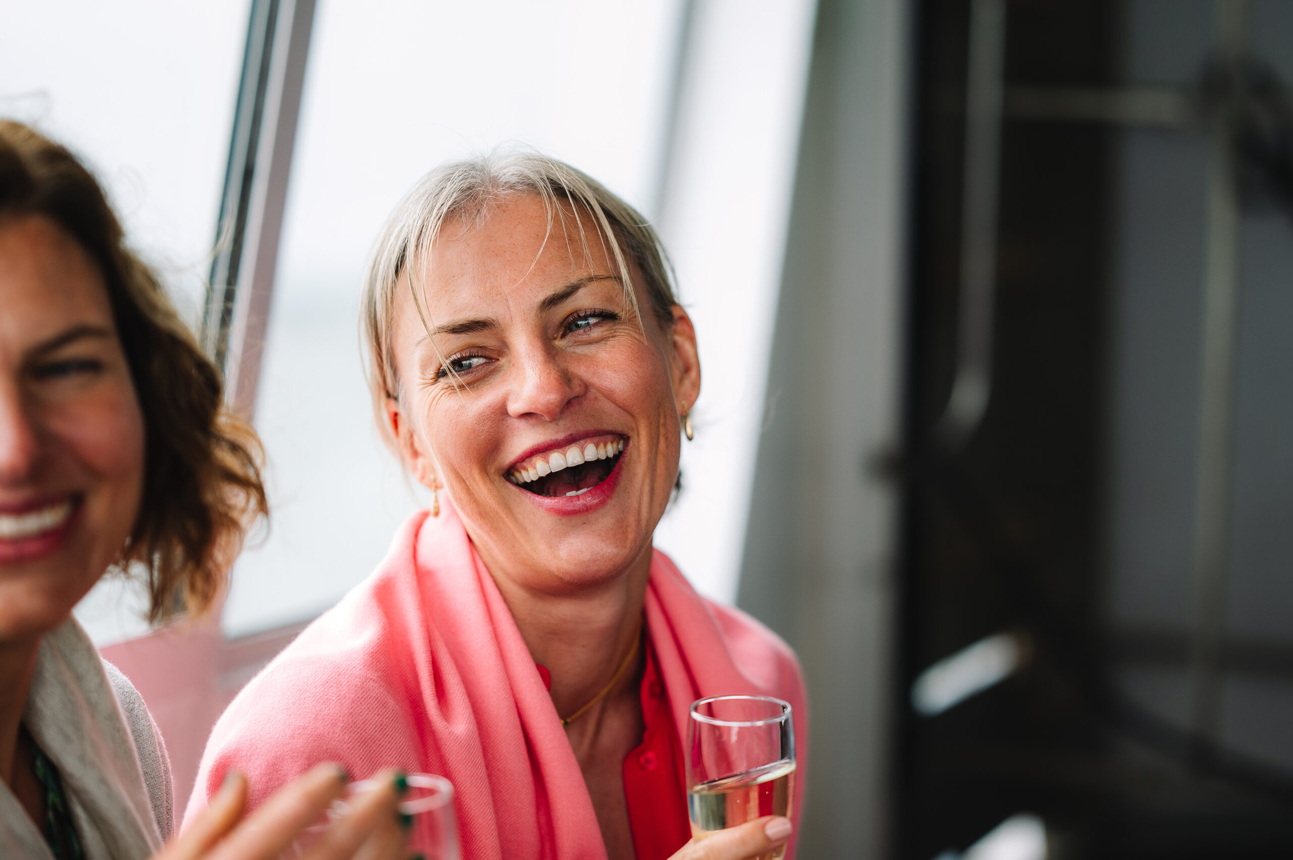 Woman smiling with friends on a boat to loch Inchcolm Island