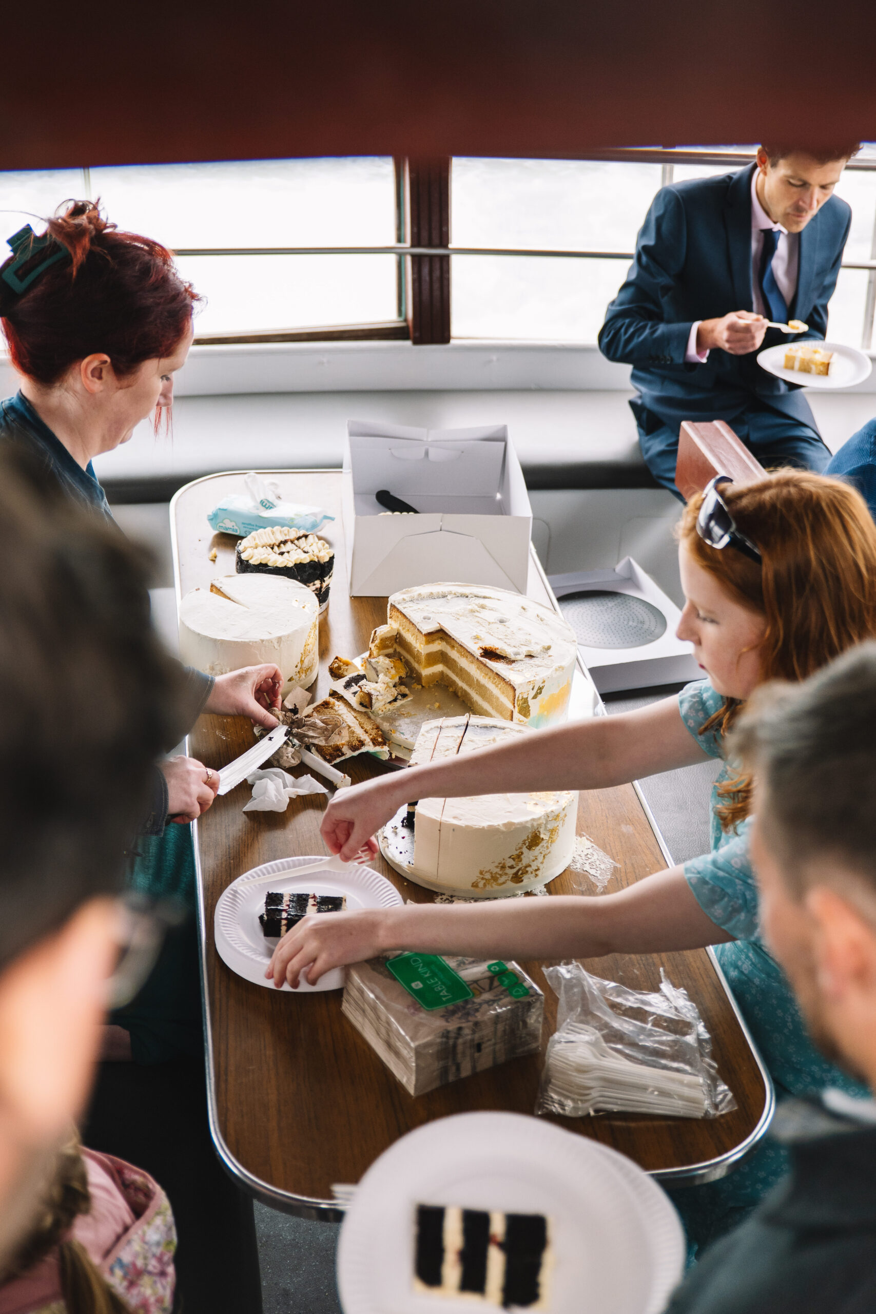 Wedding cake cutting and being shared on a boat to loch Inchcolm Island