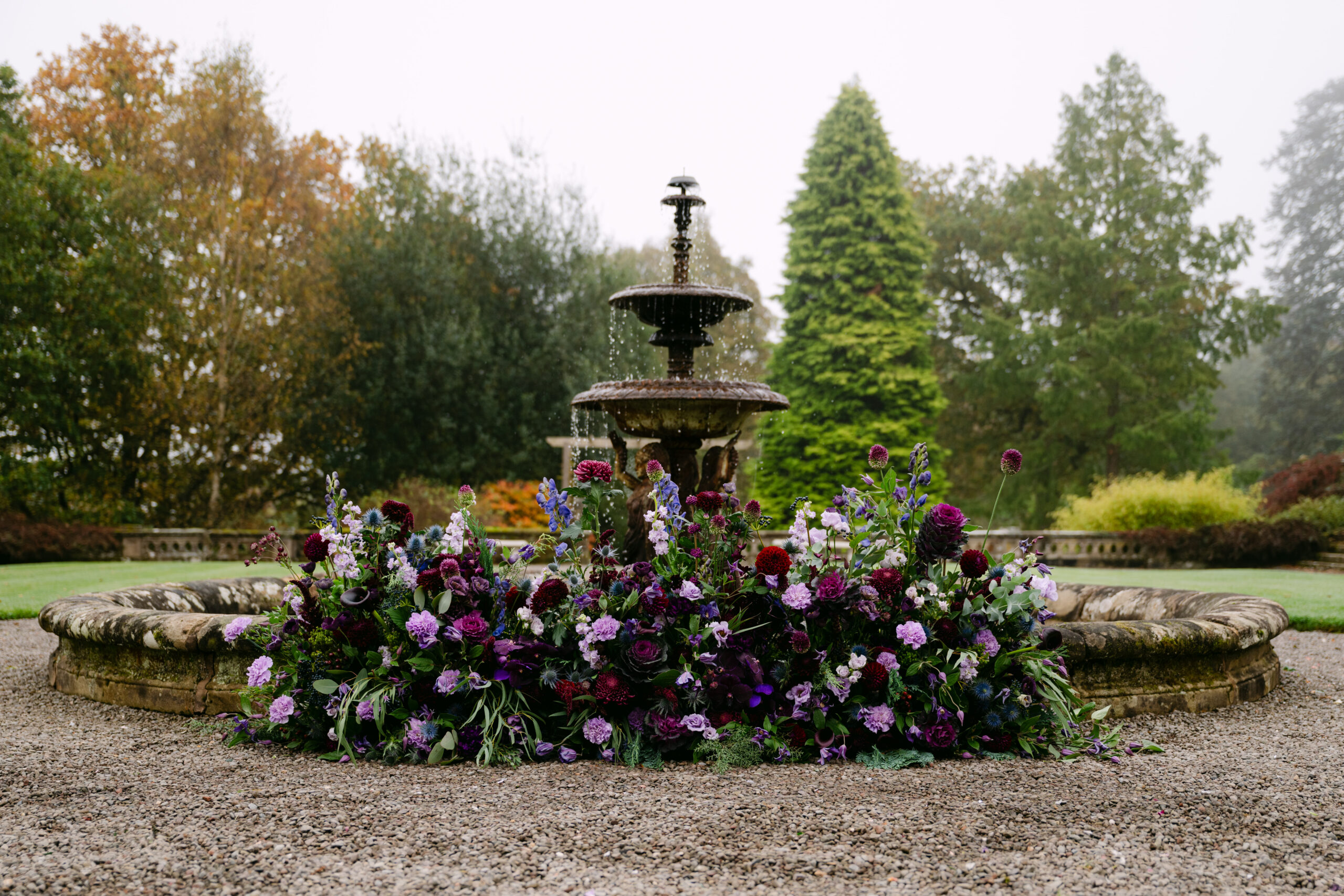 Wedding Purple Flowers in front of fountain auchen castle